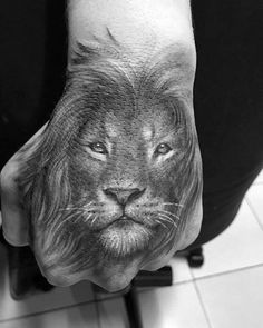 a man's hand with a lion tattoo on it