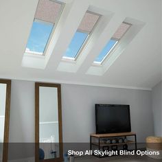 a living room with three skylights and a television