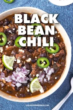 black bean chili in a white bowl with limes and cilantro on the side