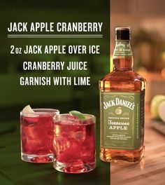 a bottle of jack apple cranberry next to two glasses