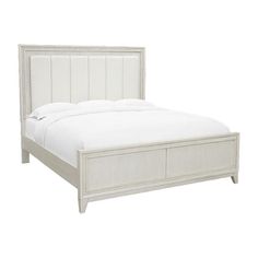 the bed is made with white linens and has an upholstered headboard