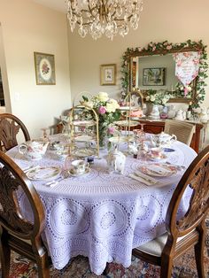 a dining room table is set with dishes and teacups for afternoon tea party