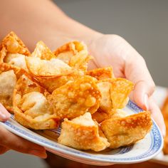 a person holding a plate with some food on it