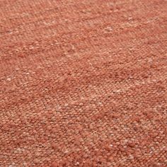 an orange area rug with small white dots on the top and one brown dot at the bottom