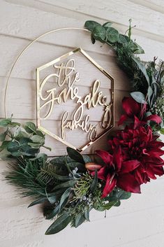 the garden lady sign is surrounded by greenery and red poinsettis on a white wall