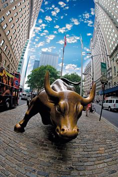 a statue of a bull laying on top of a brick road