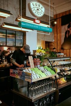 a man standing in front of a counter filled with drinks