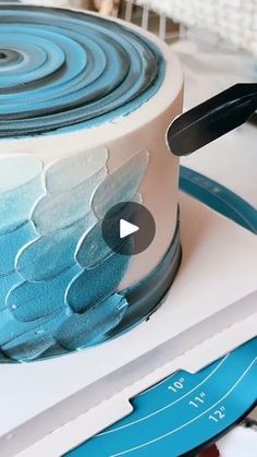 a video demonstrating how to decorate a cake with blue icing and white frosting