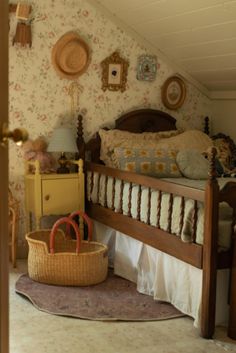 a bed room with a basket on the floor next to it and wallpapered walls