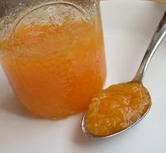 a glass jar filled with liquid next to a spoon