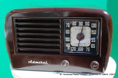 an old fashioned radio sitting on top of a white table next to a green wall