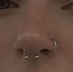 a woman with three piercings on her nose