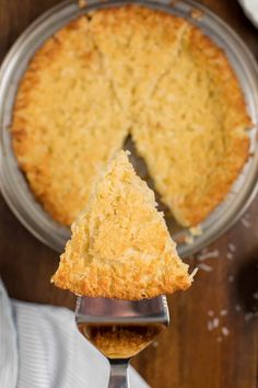 a piece of pie on a fork with the rest of it being held up by a serving spoon