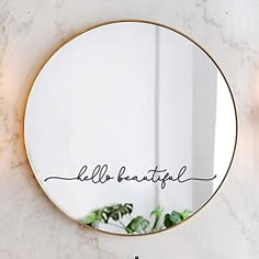 a round mirror with the word hello beautiful written on it