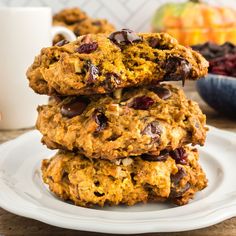 chocolate chip cookies stacked on top of each other with cranberries and oranges in the background