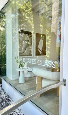 there is a glass window that says the pilates class studio in front of it