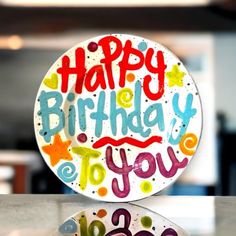 a happy birthday plate sitting on top of a table next to a bowl with the words happy birthday to you written on it