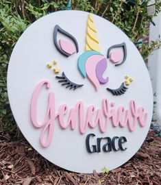 a white sign with pink lettering and a unicorn face on it that says, general grace