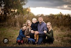 a family poses for a photo in a field