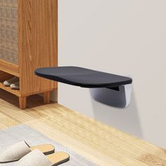 a pair of slippers sitting on top of a wooden floor next to a shelf