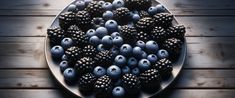 blueberries and blackberries are arranged on a plate