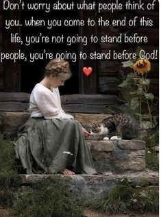 a woman sitting next to a cat on top of a stone wall with a quote