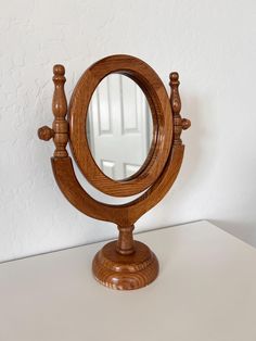 a wooden mirror sitting on top of a table