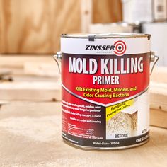 a can of mold killing primer sitting on top of a wooden table next to a piece of plywood