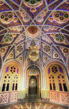 an ornate ceiling with chandeliers and windows in a building that has intricate designs on it