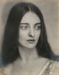 an old photo of a woman with long hair