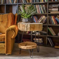 a chair and table in front of a bookshelf with many books on it