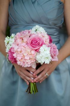 a bridesmaid holding a bouquet of pink and white flowers