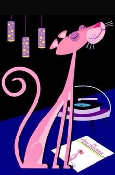 a pink cat sitting on top of a table next to a record player and some lights