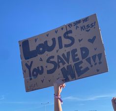 a person holding up a sign that says louis you saved me with writing on it