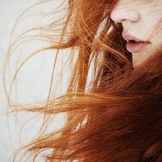 a woman with red hair blowing in the wind