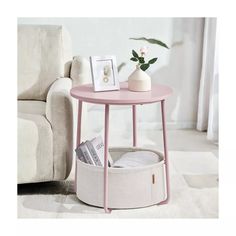 a pink table with a magazine rack on it and a white couch in the background