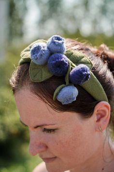 a woman wearing a headband with blue flowers on it