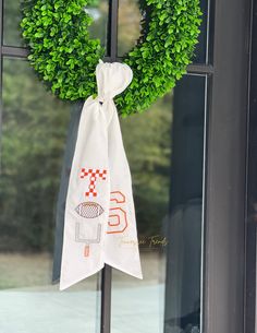 a green wreath hanging on the front door