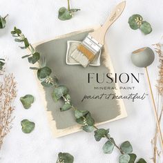 a brush and some plants on a white surface with the words, fusion mineral paint