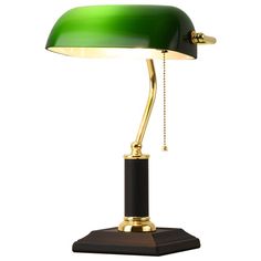 a green table lamp with a black base and gold trim on the top, sitting on a wooden stand