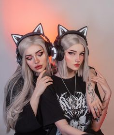 two women with cat ears and headphones on their heads are posing for the camera