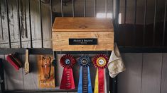 several ribbons are hanging on the wall next to a wooden box with a plaque that reads, above and beyond