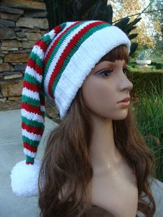 a mannequin head wearing a knitted hat with red, white and green stripes