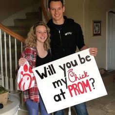 a man and woman holding a sign that says will you be my chick at prom?