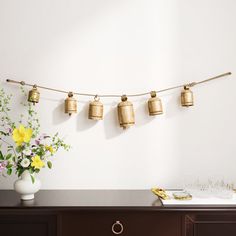 a vase filled with flowers sitting on top of a wooden table next to a wall