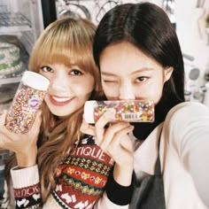 two young women holding up candy bars in front of their faces