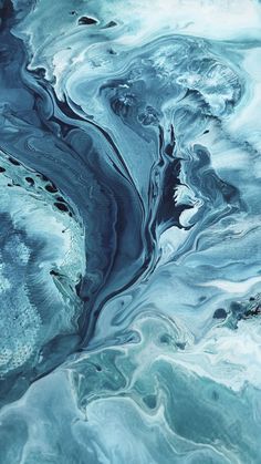 an aerial view of blue and green water with white swirls on it's surface