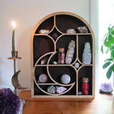 a wooden shelf filled with rocks and candles