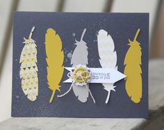 a card with some yellow and white feathers on it