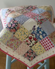 a patchwork quilt sitting on top of a stool